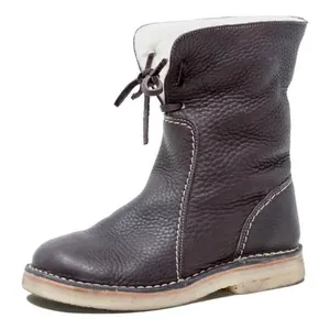 Side view detail of a brown leather winter boot with white faux fur lining and contrast stitching