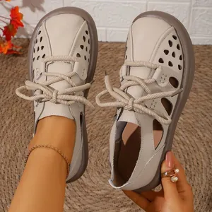 Detail view of breathable beige hollow-out summer leisure shoes with thick rope laces.