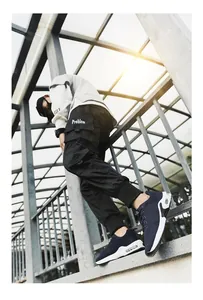 Stylish navy blue fly-knit men's sports sneakers with air cushion sole outdoors.