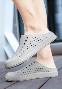 Close-up of grey breathable perforated garden clogs on a wooden deck background.