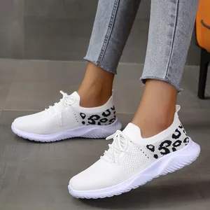 Detailed view of white mesh casual sneakers with leopard print accents and lace-up design.