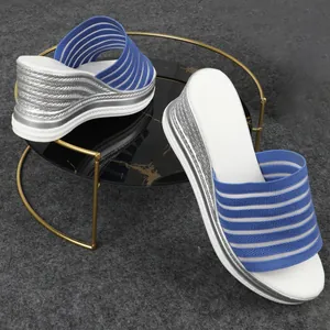 Modische blau-weiß gestreifte Fly-Knit-Keilsandaletten auf elegantem Displayständer