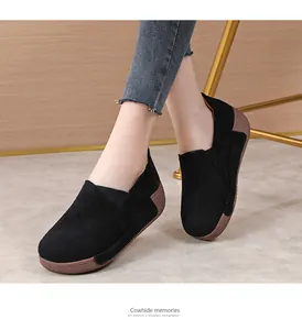 Close-up detail of stylish black cowhide platform rocker shoes worn by model on grey floor