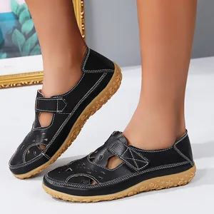 Detail view of women's black hollow-out flat sandals with floral patterned sole