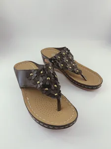 Vista dettagliata dei sandali con zeppa da donna con fiori e borchie dorate eleganti
