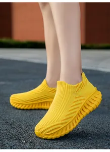 Detailed close-up view of bright yellow fly-knit slip-on sneakers for active outdoor wear