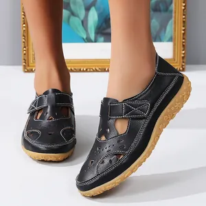 Detailed view of women's black hollow-out flat beach sandals on model feet