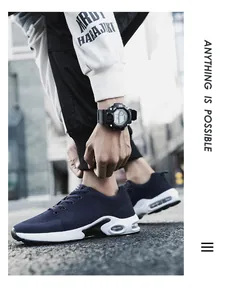 Detailed side view of navy blue fly-knit fashion sneakers featuring a white air cushion sole.