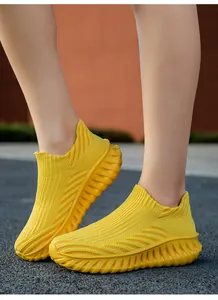 Close-up detail of breathable yellow fly-knit slip-on sneakers for running and walking