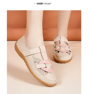 Close-up view of beige leather hollow-out flat sandals worn by a model for summer wear