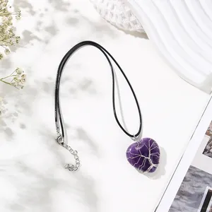 Close-up detail of wire wrapped tree of life on heart shaped amethyst pendant