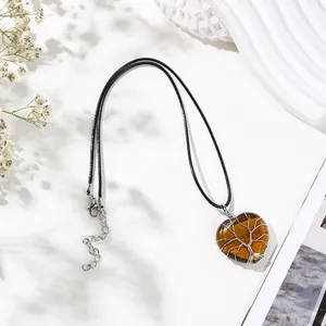 Close-up of heart-shaped Tiger's Eye pendant with intricate Tree of Life wire wrap detail
