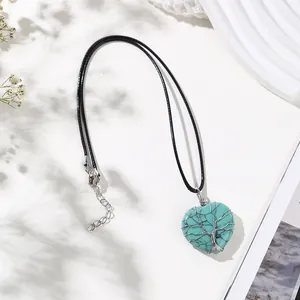 Heart turquoise pendant necklace with wire-wrapped tree of life design on white background