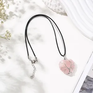 Close-up of pink crystal heart pendant with silver wire-wrapped tree of life design