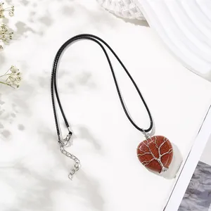 Close-up of heart-shaped goldstone pendant with silver wire-wrapped tree of life detail.
