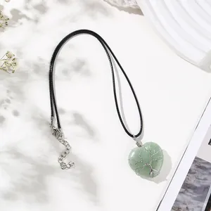 Close-up of heart-shaped green crystal necklace with Tree of Life wire wrap