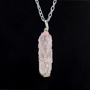 Detailed close-up of a handmade tree of life wire-wrapped rose quartz crystal necklace