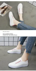 Λεπτομερής προβολή λευκών δερμάτινων sneakers με κόκκινα μάτια και στρογγυλή μύτη