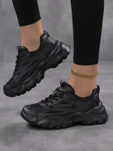 Vue rapprochée de baskets noires à semelle épaisse pour femmes au style chunky.