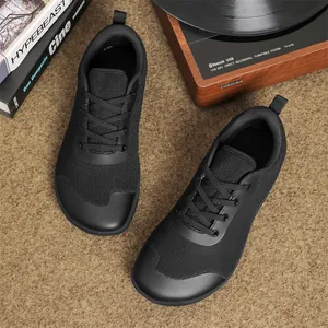Detailed view of black wide-toe barefoot shoes with breathable flyknit fabric.