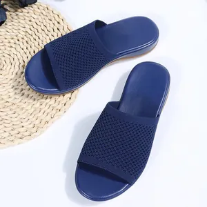Gros plan sur la texture tricotée bleu marine de pantoufles plates confortables