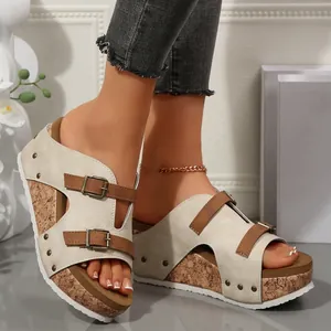 Detail view of peep-toe wedge sandals featuring cork platforms and rivet buckle straps.