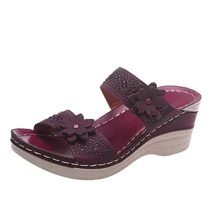 Detail of purple wedge sandal featuring 3D flowers and sparkling rhinestone accents.