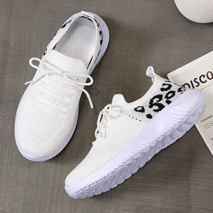 Detail shot of breathable white mesh sneakers featuring a leopard print heel and lace-up closure