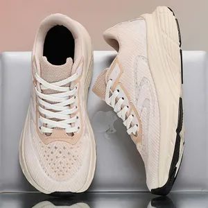 Detail of beige breathable flyknit wide-fit running shoes for men on a silver laptop surface.