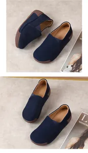Macro detail view of navy blue suede casual loafers featuring thick brown rubber soles.