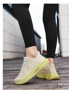 Close-up of women's wide toe flyknit running shoes worn by a model on a wooden deck.