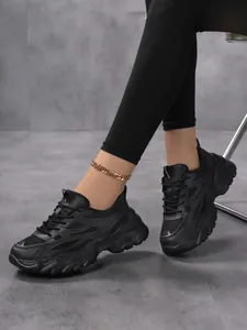 Vue détaillée des baskets noires épaisses pour femmes avec semelles compensées élégantes.