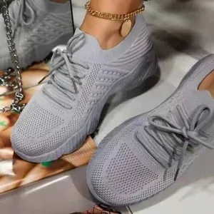Gros plan sur des baskets grises en maille fly-knit pour femmes, confortables et respirantes.
