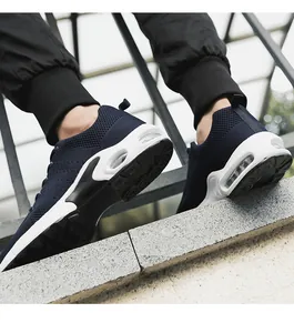 Close-up detail of navy blue flyknit men's sports sneakers featuring white air cushion soles