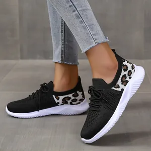 Close-up of women's black mesh sneakers with stylish leopard print details on feet.