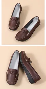 Close-up of brown textured leather loafers with white stitching and braided detail.