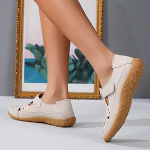 Close-up detail of women's hollow leather flat sandals with floral pattern sole