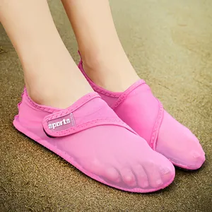 Close-up of pink breathable mesh beach swimming shoes on sandy ground