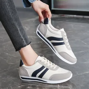 Stylish cream and navy blue lace-up casual sneakers for women with grey suede details
