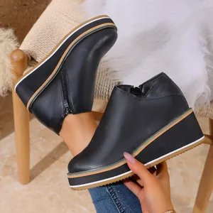 Détail de bottines à semelle compensée noire avec fermeture éclair et semelle rayée