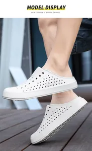 Close-up side view of white breathable perforated summer clogs worn by a model outdoors