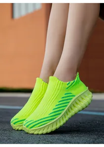 Close-up view of lime green breathable flyknit slip-on sneakers for casual outdoor running activities