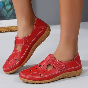 Detail view of stylish red hollowed-out flat sandals for women with adjustable Velcro strap