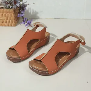 Detail van oranje sleehaksandalen met contrasterende stiksels