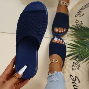 Detailed view of navy blue knit thick-sole sandals on a stylish summer resort mat