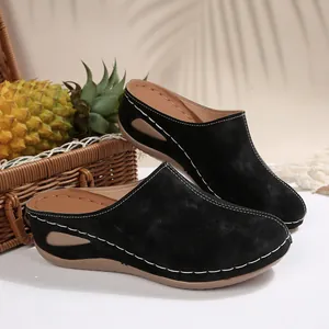 Women's black suede wedge mules with white decorative stitching and cutout sole detail