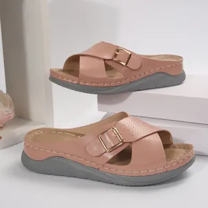 Close-up view of women's dusty rose cross-strap wedge sandals with elegant gold buckle