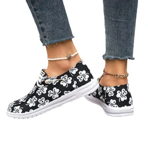 Women's black canvas loafers with white shamrock print for St. Patrick's Day celebration