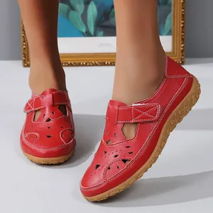 Close-up detail of stylish red hollow-out leather flat sandals for women's summer