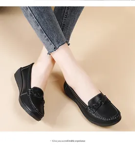 Close-up of comfortable black flat leather loafers with braided detail worn by a model
